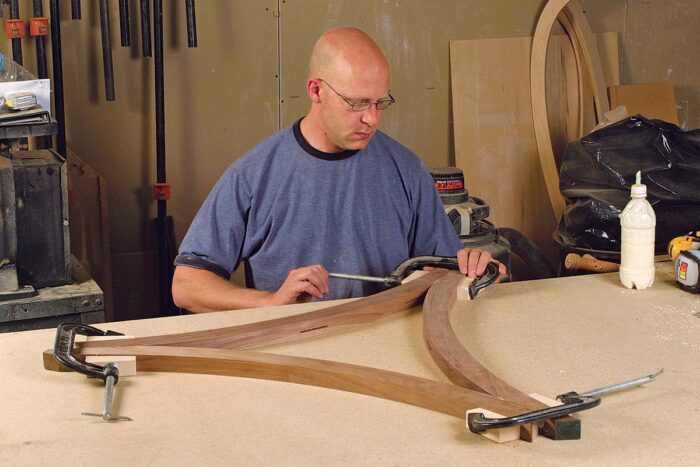 Glue up the triangle frame. After cutting slots along the inside edge of the frame (used to attach the panel), glue and clamp the parts on a flat surface.