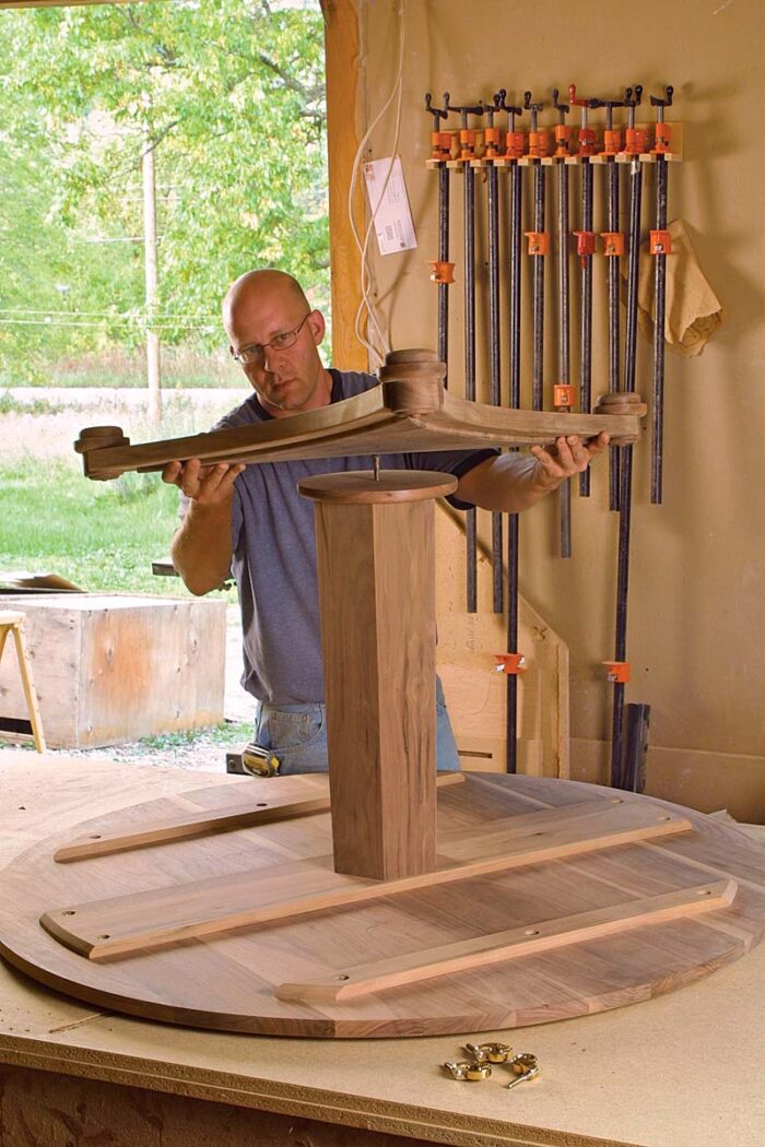 The curved parts that make up the triangular base of the table are shaped using a router mounted to a large trammel device.