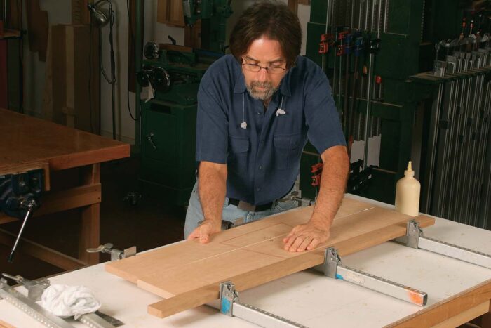 More force applied. Place clamps on top of the glue-up. Then tighten down all of them, applying firm, even pressure.