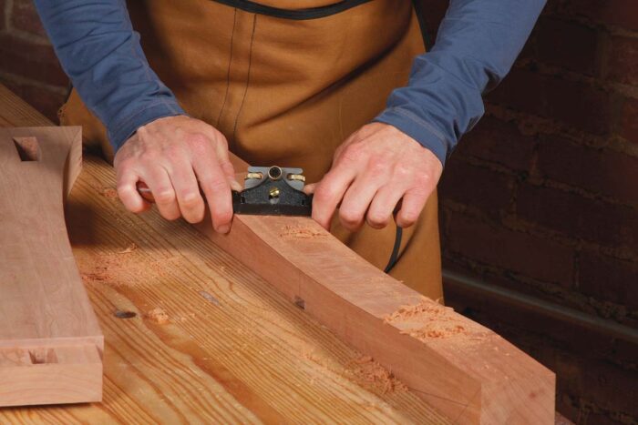 A spokeshave or card scraper works great on the curved bottom. Use a handplane on the tapers.