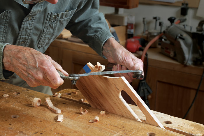 Becksvoort works halfway through one side, flips the piece over, and removes the rest. Then he uses a drawknife to shape the scooped ends of the handle.