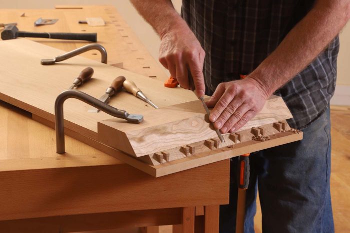 Then I pare the pin board's miter clean using a 20-in. batten with one of its long edges sawn to a 45° bevel.