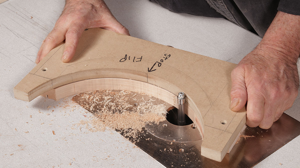 <strong>Rout downhill.</strong> On this U shape, Van Dyke stops each pass at the apex of the curve. For this pass, with the template above the workpiece, he uses a flush-trimming bit.