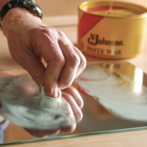 Applying wax to a mirror to test for lumps