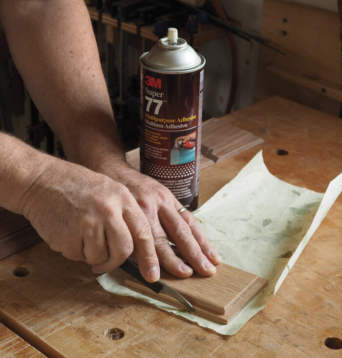 It’s easiest to spray the box bottom with a light mist of adhesive, drop it onto the paper, and trim around it.