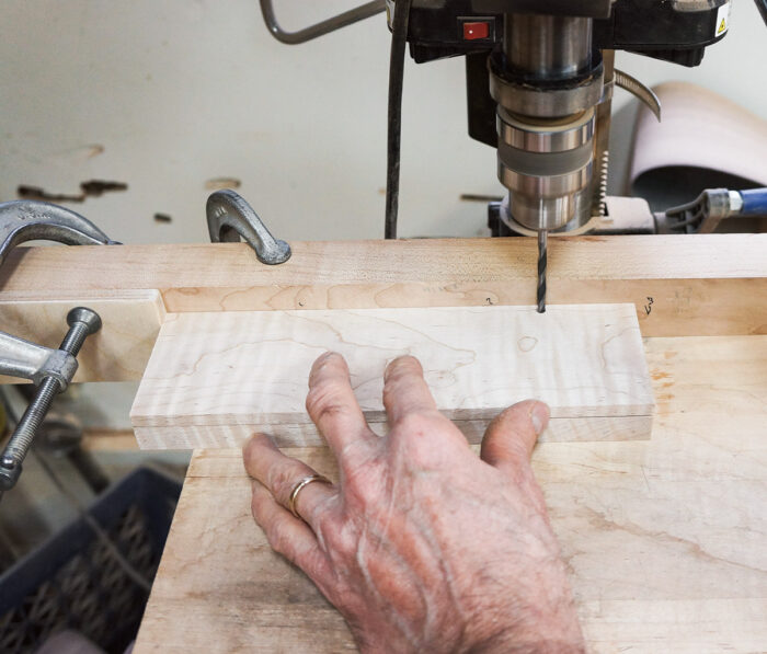 To drill the matching holes in the lids, use one lid to prop up and level the other. The spacer blocks are not used as the lids are positioned against each stop block for drilling