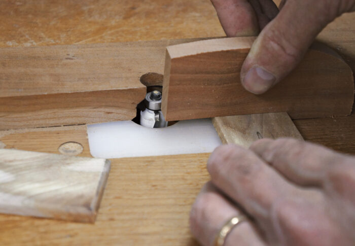 Round the edges of the box lid on a router table.