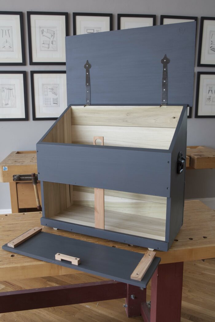 An empty tool chest sitting on a bench with the lids open.