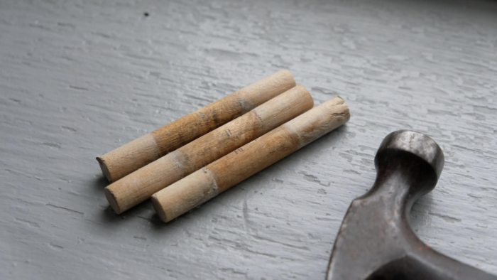 Pegs for an Amana Church Bench, next to a hammer