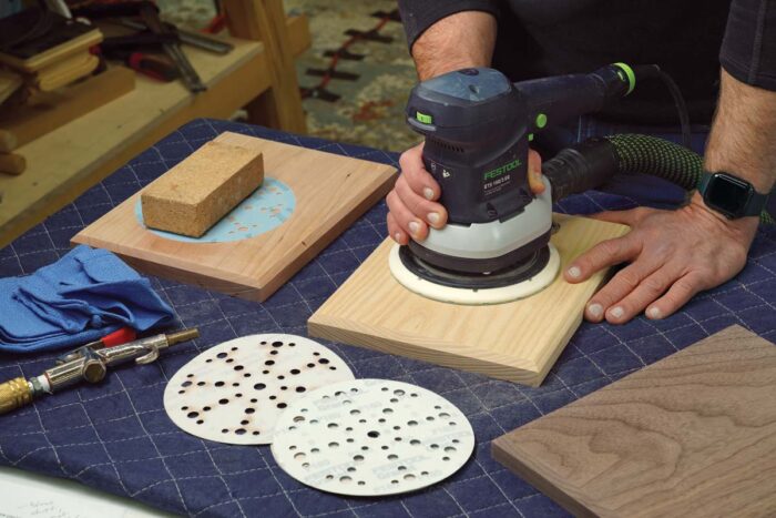 A piece of wood being sanded with a random-orbit sander